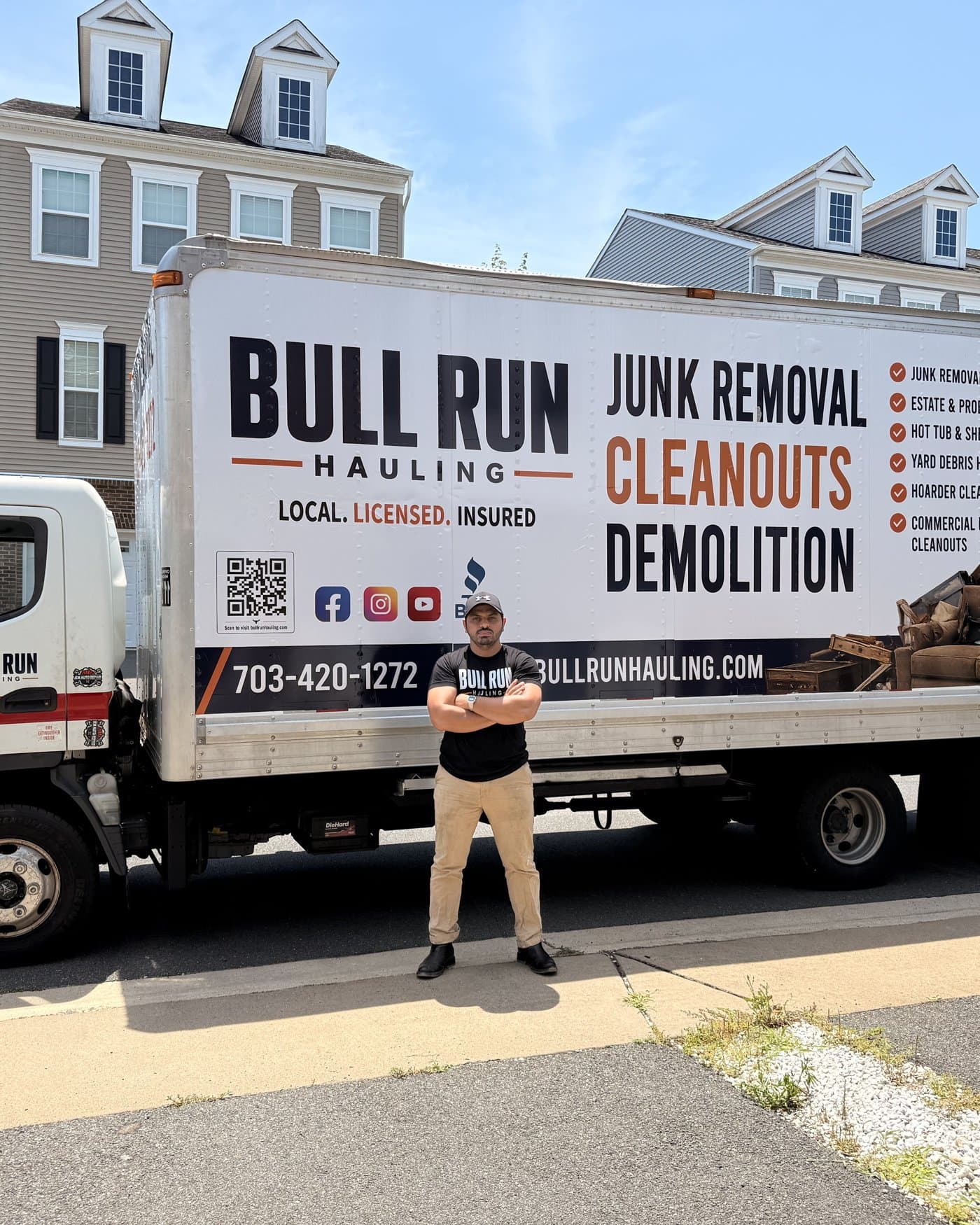 Bull Run Hauling owner standing in front of the truck on a job site